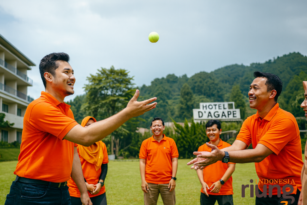 Permainan lempar bola santai peserta di area lapangan