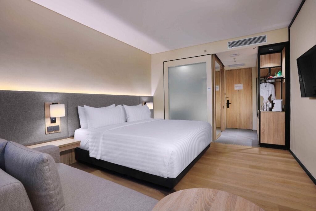 Kamar suite mewah Grand Aston Puncak dengan balkon pribadi 
menghadap Gunung Pangrango. 